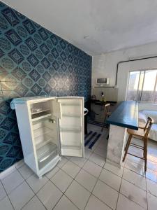 a small kitchen with a refrigerator and a table at Santorini Flats in Arraial do Cabo