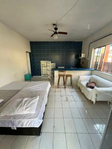 a bedroom with a bed and a couch and a table at Santorini Flats in Arraial do Cabo