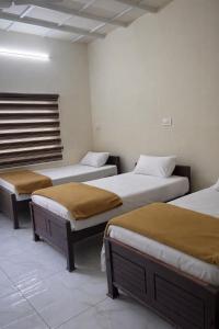 a room with three beds in a room at WAYNEST by SHELTERS in Meppādi