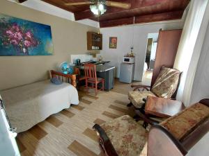 a bedroom with a bed and chairs and a kitchen at Uncle Charlie in Kroonstad