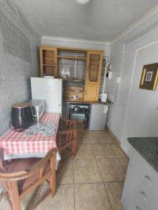a small kitchen with a table and a refrigerator at Uncle Charlie in Kroonstad +10 photos