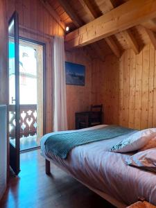 a bedroom with a bed in a wooden room at Villa Silote in La Grave