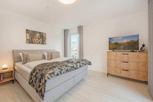 a bedroom with a bed and a dresser and a window at Hart Backbord in Loddin