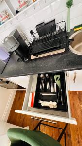 a drawer in a kitchen filled with utensils at Broadway Apartment in London +10 photos