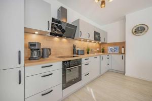 a kitchen with white cabinets and a stove top oven at Hart Backbord in Loddin