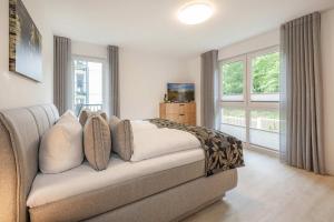 a bedroom with a couch and a large window at Hart Backbord in Loddin