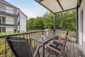 a patio with a table and chairs on a balcony at Hart Backbord in Loddin