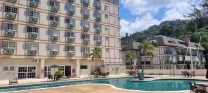 a hotel with a swimming pool in front of a building at Serra & Sossego in Araras Petropolis +19 photos