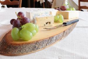 a wooden plate with cheese and grapes on a table at Budget Messehotel by Daucher in Nuremberg