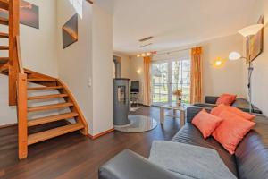 a living room with a couch and a staircase at Ferienhaus "Ferien am Haff" in Zirchow