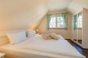 a large white bed in a room with a window at Ferienhaus "Ferien am Haff" in Zirchow