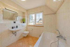a bathroom with a tub and a sink and a toilet at Ferienhaus "Ferien am Haff" in Zirchow +25 photos