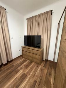 a living room with a flat screen tv on a dresser at Old Stone House in Mlini