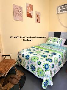 a bedroom with a bed and a chair at Belechl Ranch Studio Rental - Cozy Compact Room with Private Bathroom in Koror