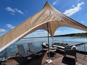 a patio with chairs and a couch on a boat at Floatinghouse Möwe 2 - LP2 in Vetschau