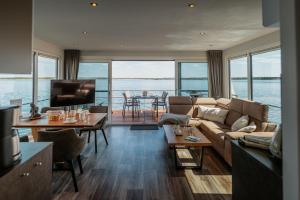 a living room with a couch and a view of the water at Floatinghouse Möweninsel - LP15 in Vetschau