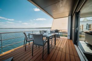 a balcony with a table and chairs on a yacht at Floatinghouse Möweninsel - LP15 in Vetschau +11 photos