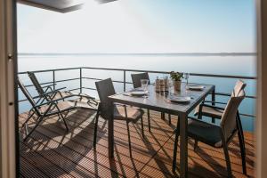 a table and chairs on a balcony with the ocean at Floatinghouse Möweninsel - LP15 in Vetschau