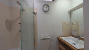 a bathroom with a sink and a clock on the wall at Le jardin Provençal in Saint-Saturnin-lès-Avignon +12 photos