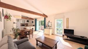 a living room with a couch and a table at Le jardin Provençal in Saint-Saturnin-lès-Avignon