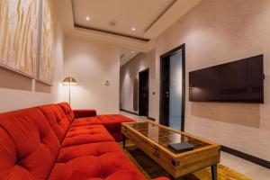 a living room with a red couch and a tv at D'avenue Boutique Hotel Accra in Accra