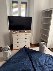 a bedroom with a flat screen tv and a dresser at Old Stone House 2 in Mlini