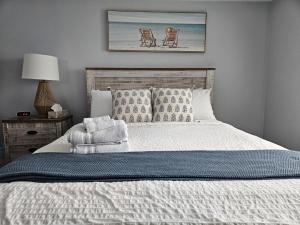 a bedroom with a bed and a picture of a chair at Casa Azul- Entire Lakefront Cottage with Hot Tub in Leamington +57 photos