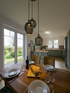 a dining room with a table with plates and glasses at Ferienhaus Das Petermännchen in Fehmarn