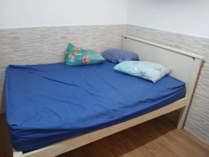 a bed with blue sheets and two pillows on it at Pousada Coutinho in Paraty