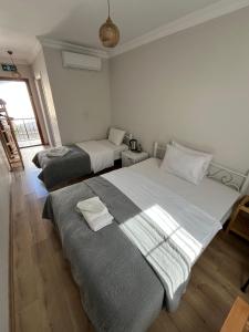 a bedroom with two beds and a window at Lokal Ayvalık Guest House in Ayvalık