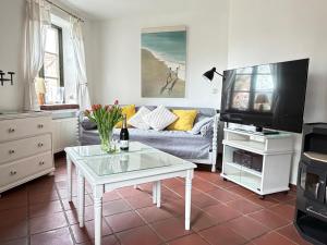 a living room with a couch and a tv at Kleine Meerzeit in Maasholm