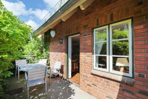 a brick building with a table and chairs on a patio at Kleine Meerzeit in Maasholm