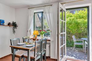 a dining room with a table and chairs and an open door at Kleine Meerzeit in Maasholm
