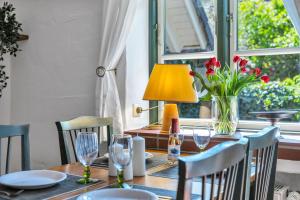 a dining room table with a vase of flowers and a lamp at Kleine Meerzeit in Maasholm +9 photos