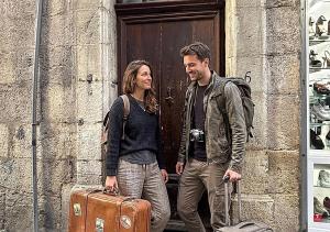 a man and woman standing in front of a door with luggage at Grand studio 31 m2 plus mezzanine centre ville grasse in Grasse