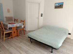 a bedroom with a bed and a table and chairs at Chez Bonjour in Villar Pellice