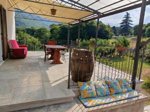 a patio with a barrel and a table and a chair at Chez Bonjour in Villar Pellice
