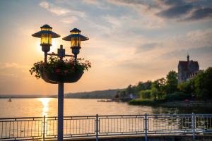 a lamp post with a flower pot on it next to a river at Ferienwohnung Seese Wansleben am See in Wansleben