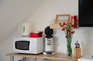 a microwave and a vase with flowers on a table at Le Relais de Poste in Orbigny +14 photos