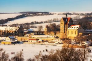 a small town in the snow with a church at Ferienwohnung Seese Wansleben am See in Wansleben