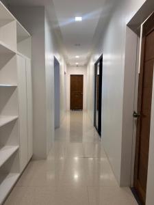 a hallway with white walls and a wooden door at Casa G in Bacong