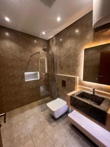 a bathroom with a sink and a toilet and a shower at luxury rooftop apartment in Jeddah +19 photos