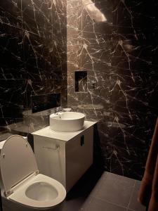 a bathroom with a white toilet and a sink at Casa G in Bacong