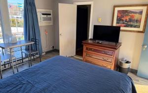 a bedroom with a bed and a table and a television at Pineapple Inn in North Attleboro