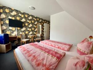 a bedroom with two beds with pink covers and a piano at Zum Schlossgarten in Ralswiek