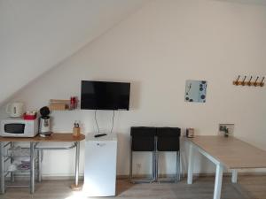 a room with a table and a tv on the wall at Le Relais de Poste in Orbigny