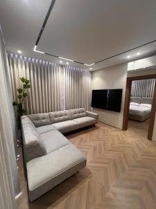 a living room with a couch and a flat screen tv at luxury rooftop apartment in Jeddah