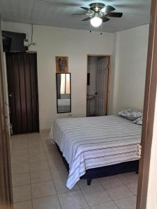 a bedroom with a bed and a ceiling fan at Hostal Inmaculada in Concepción de Ataco +18 photos
