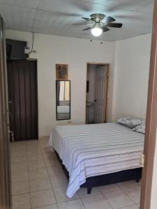 a bedroom with a bed and a ceiling fan at Hostal Inmaculada in Concepción de Ataco