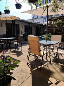 an outdoor patio with tables and chairs and umbrellas at Hostal Inmaculada in Concepción de Ataco